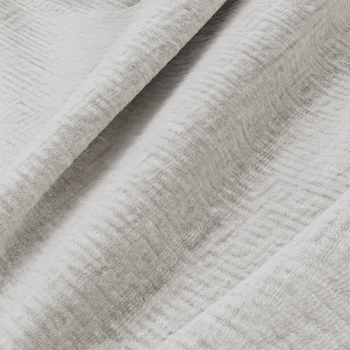 Panoramische sofa links, bekleed met crèmekleurig fluweel met patroon.